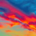 Bildnachweis 103 Dramatisches Abendrot vor Schlechtwetterfront mit orange-rote Wolken über einen gelb-grünen-blauen Hintergrund.