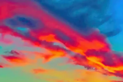 Dramatisches Abendrot vor Schlechtwetterfront mit orange-rote Wolken über einen gelb-grünen-blauen Hintergrund.
